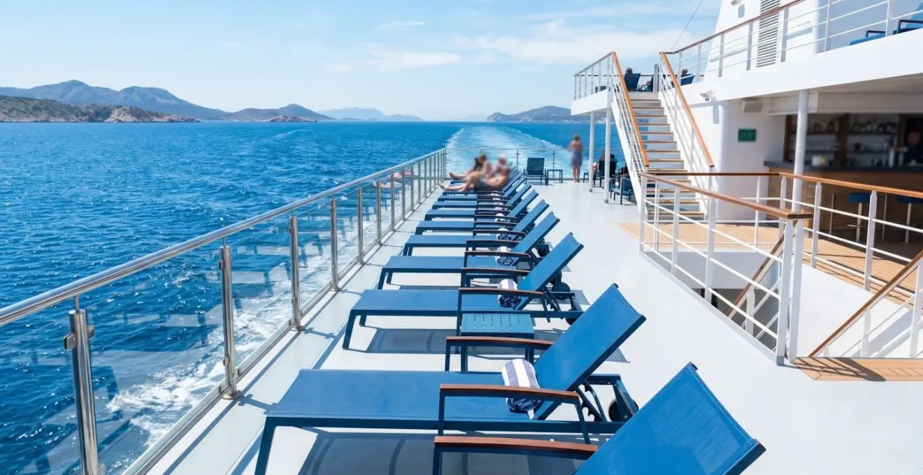 Leeres Aussendeck einer zeitgenössischen Autofähre mit blauen Liegestühlen und Blick auf das azurblaue Mittelmeer unter strahlendem Sonnenlicht